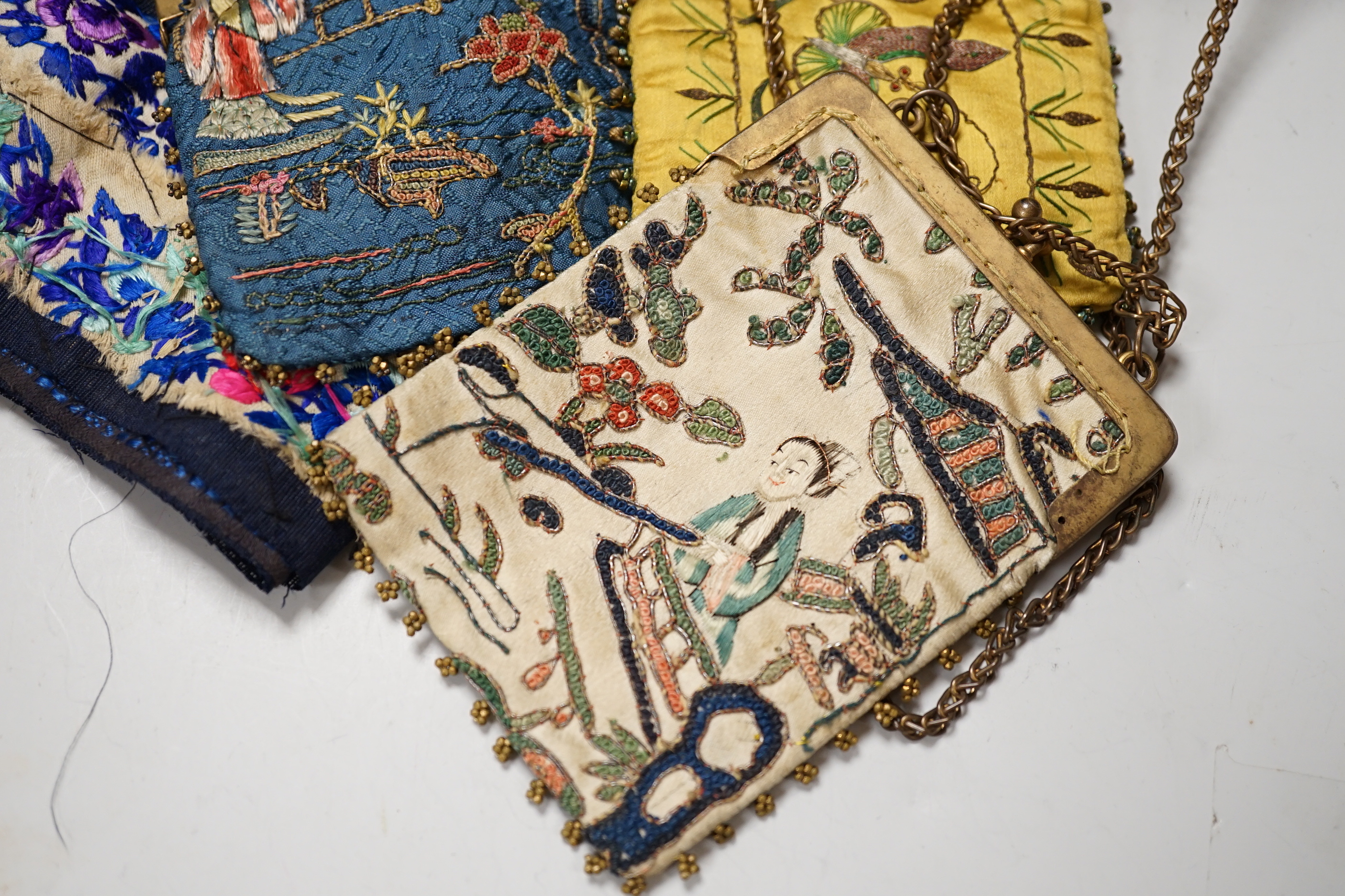 A lacquer box of Chinese embroidered purses and embroideries.